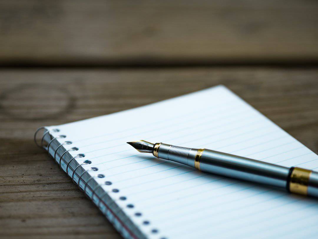 Pen and a book to write a cover letter draft