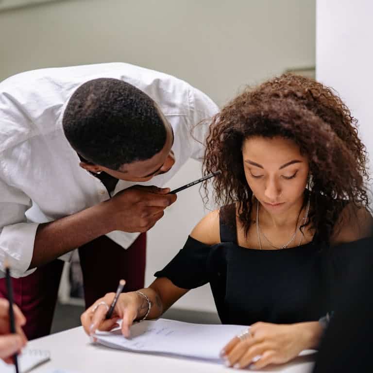 A Man Pointing a Pencil to a Woman trying to resolve conflict in the workplace