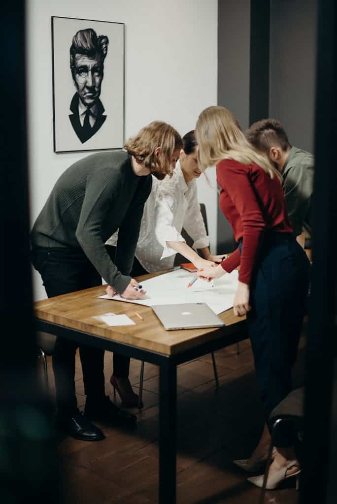 Women and Men Standing Near Table working to rephrase words to better communicate their ideas